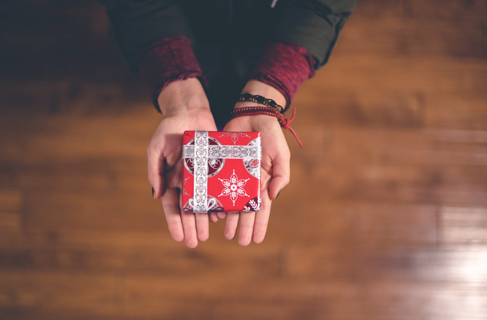 Close-up of a person's hand holding a small gift box.